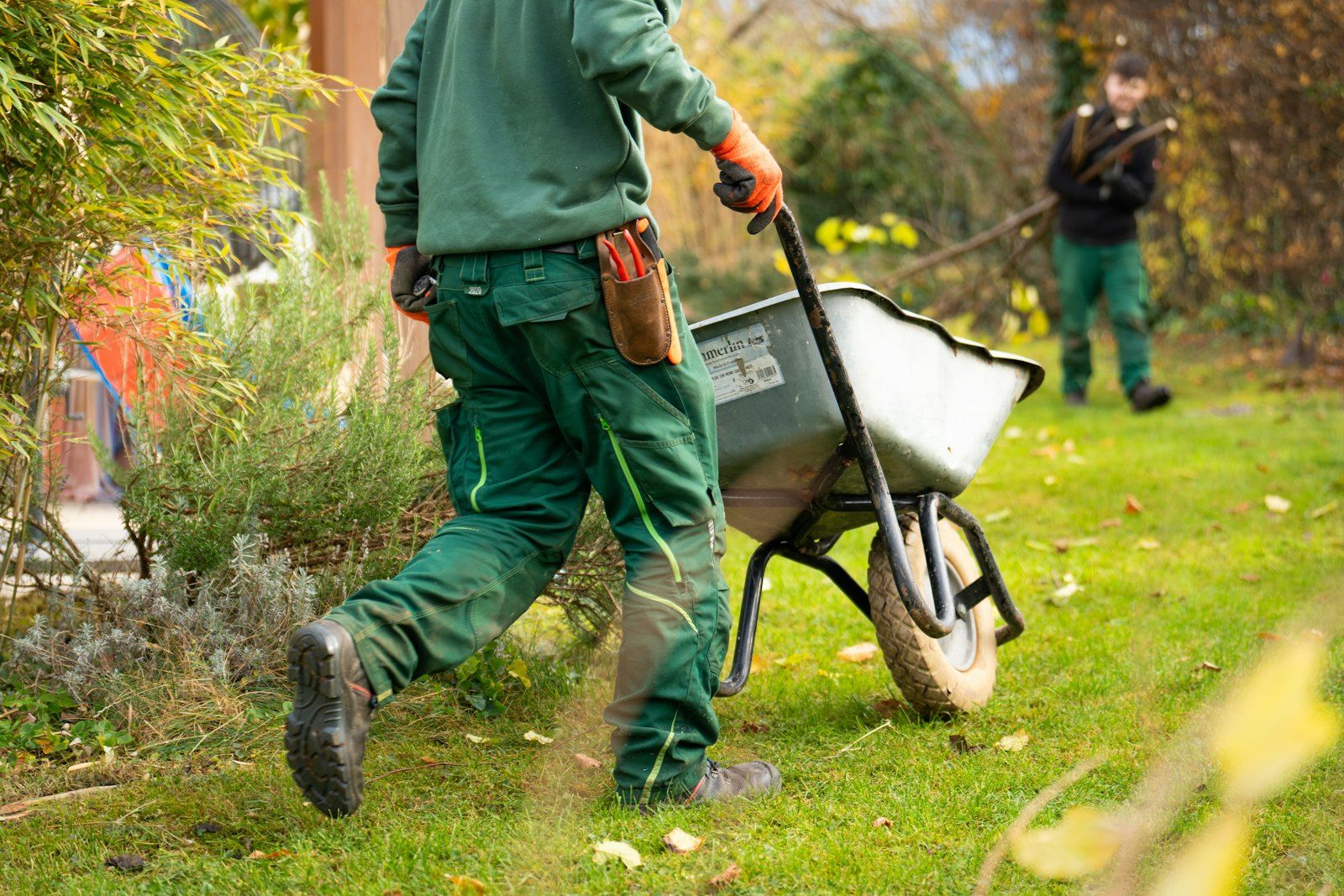 Jardinier qui pousse une brouette dans un jardin